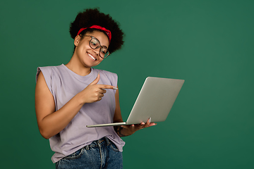 Image showing African-american woman\'s portrait isolated on green studio background with copyspace