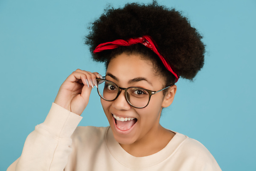 Image showing African-american woman\'s portrait isolated on blue studio background with copyspace