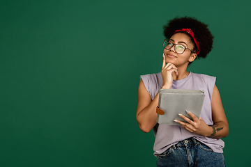 Image showing African-american woman\'s portrait isolated on green studio background with copyspace