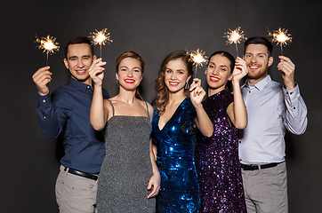 Image showing happy friends in party clothes with sparklers