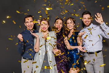 Image showing happy friends at party under confetti over black