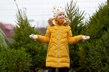 Image showing little girl choosing christmas tree at market