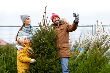 Image showing family taking selfie with christmas tree at market