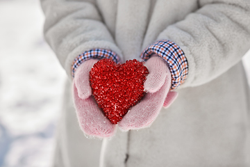 Image showing close up of little girl holding heart in winter