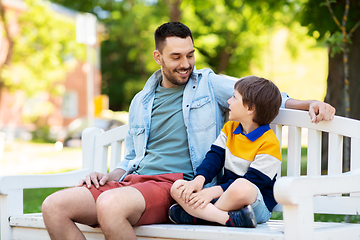 Image showing father with son sitting on park bench and talking