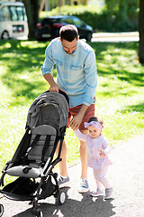 Image showing father with child and stroller walking at park