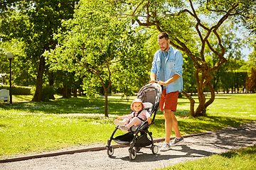 Image showing happy father with child in stroller at summer park