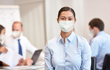 Image showing businesswoman in face protective mask at office