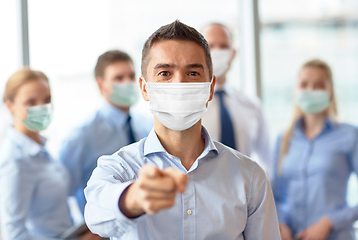 Image showing businessman in mask pointing finger at office