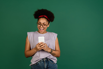 Image showing African-american woman\'s portrait isolated on green studio background with copyspace