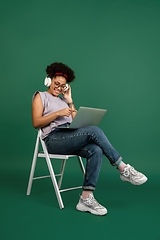 Image showing African-american woman\'s portrait isolated on green studio background with copyspace