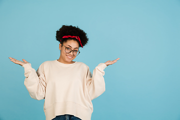 Image showing African-american woman\'s portrait isolated on blue studio background with copyspace