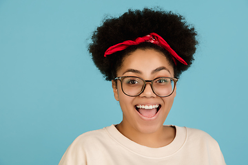 Image showing African-american woman\'s portrait isolated on blue studio background with copyspace