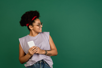 Image showing African-american woman\'s portrait isolated on green studio background with copyspace