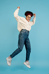 Image showing African-american woman\'s portrait isolated on blue studio background with copyspace