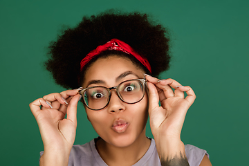 Image showing African-american woman\'s portrait isolated on green studio background with copyspace