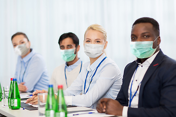 Image showing business people in masks at conference