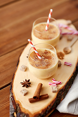 Image showing glasses of eggnog, ingredients and spices on wood