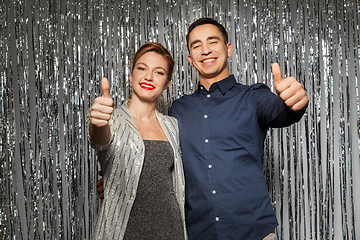 Image showing couple in party clothes showing thumbs up