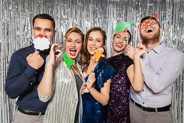 Image showing happy friends posing with christmas party props