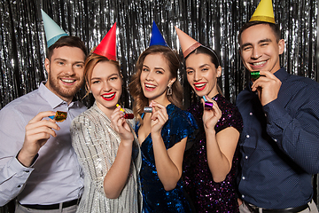 Image showing happy couple with party blowers having fun