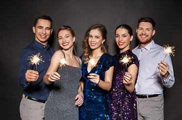 Image showing happy friends in party clothes with sparklers