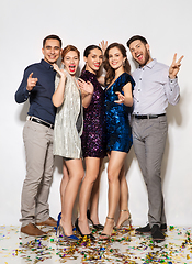 Image showing happy friends at party with confetti on floor