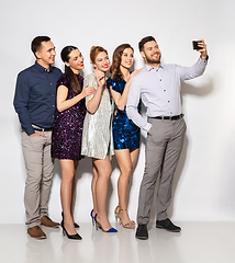 Image showing happy friends taking selfie by smartphone at party