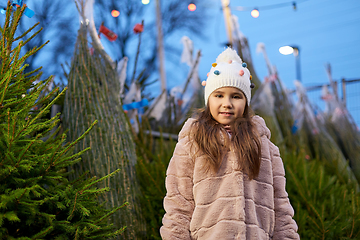 Image showing little girl choosing christmas tree at market