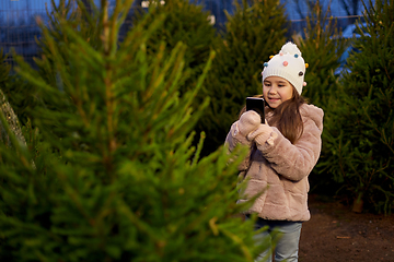 Image showing girl with smartphone at christmas tree market