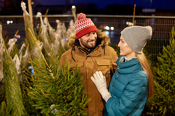 Image showing happy couple buying christmas tree at market