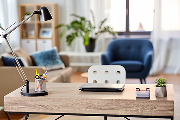 Image showing laptop and lamp on table at home office