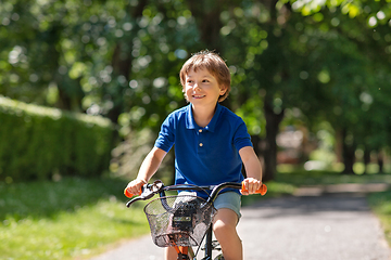 Image showing happy little boy riding bicycle at summer park