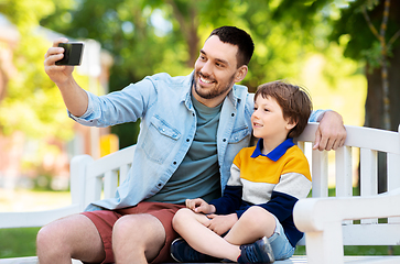 Image showing father and son taking selfie with phone at park