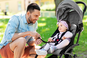 Image showing happy father with child in stroller at summer park