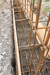 Image showing Reinforcement of the strip foundation with metal reinforcement in a trench with formwork