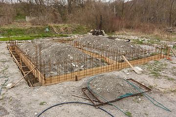 Image showing The general plan for the construction of a one-story private house, a trench has been dug, formwork and reinforcement are being installed