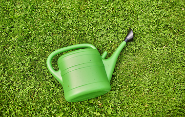 Image showing green watering can on grass at summer garden