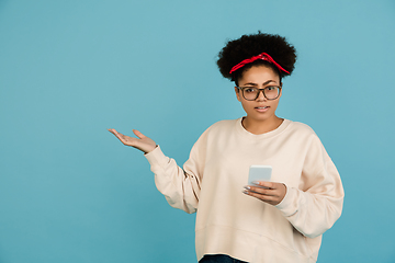 Image showing African-american woman\'s portrait isolated on blue studio background with copyspace