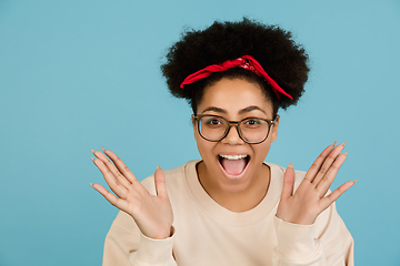 Image showing African-american woman\'s portrait isolated on blue studio background with copyspace