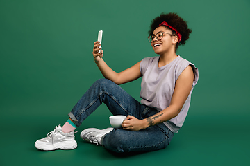 Image showing African-american woman\'s portrait isolated on green studio background with copyspace