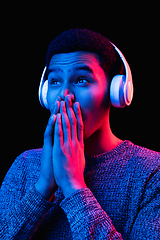 Image showing African-american man\'s portrait isolated on black studio background in multicolored neon light