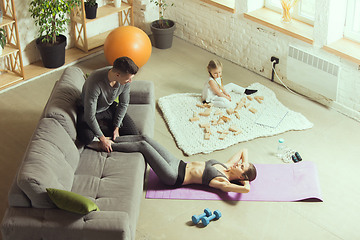 Image showing Young woman exercising fitness, aerobic, yoga at home, sporty lifestyle. Getting active during lockdown, quarantine. Home gym.