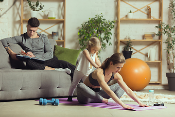 Image showing Young woman exercising fitness, aerobic, yoga at home, sporty lifestyle. Getting active during lockdown, quarantine. Home gym.