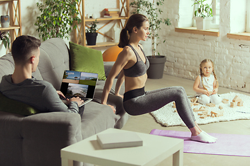 Image showing Young woman exercising fitness, aerobic, yoga at home, sporty lifestyle. Getting active during lockdown, quarantine. Home gym.