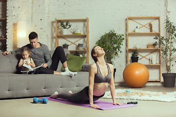 Image showing Young woman exercising fitness, aerobic, yoga at home, sporty lifestyle. Getting active during lockdown, quarantine. Home gym.