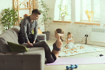 Image showing Young woman exercising fitness, aerobic, yoga at home, sporty lifestyle. Getting active during lockdown, quarantine. Home gym.