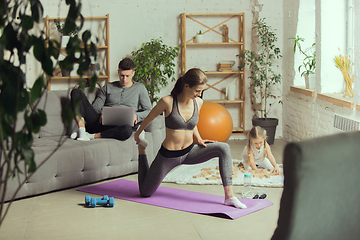 Image showing Young woman exercising fitness, aerobic, yoga at home, sporty lifestyle. Getting active during lockdown, quarantine. Home gym.