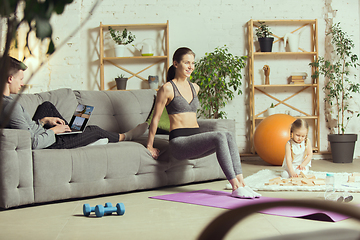 Image showing Young woman exercising fitness, aerobic, yoga at home, sporty lifestyle. Getting active during lockdown, quarantine. Home gym.