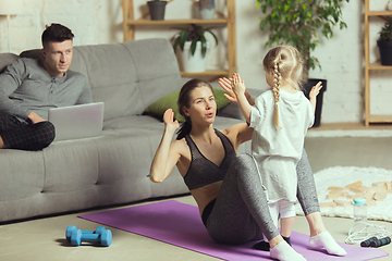 Image showing Young woman exercising fitness, aerobic, yoga at home, sporty lifestyle. Getting active during lockdown, quarantine. Home gym.